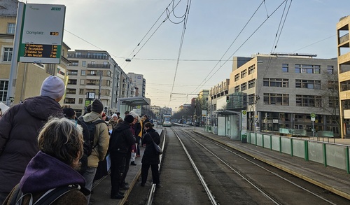 Menschen warten auf eine Straßenbahn
