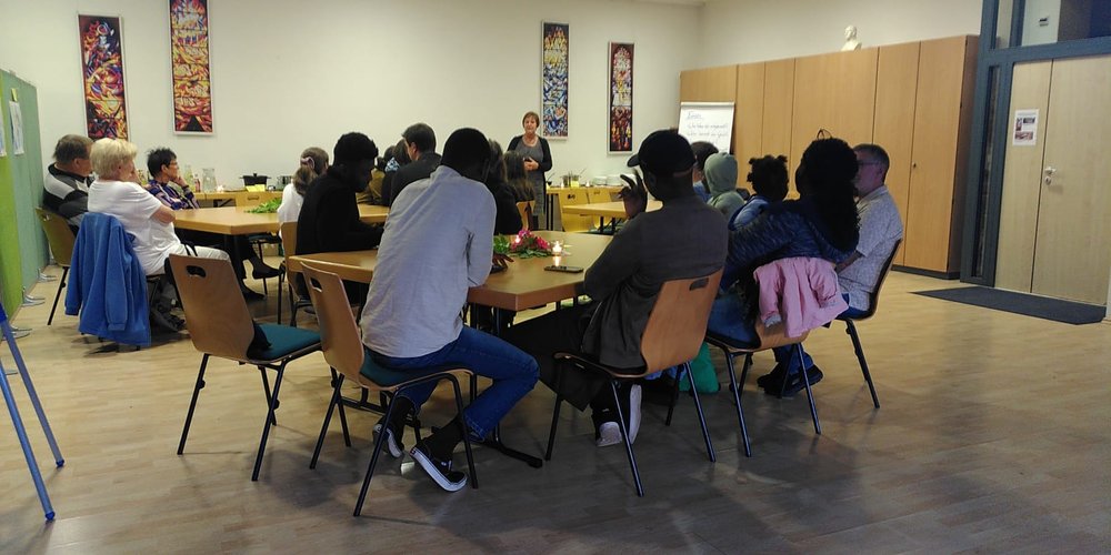 Menschen an Tischgruppen in einem Raum