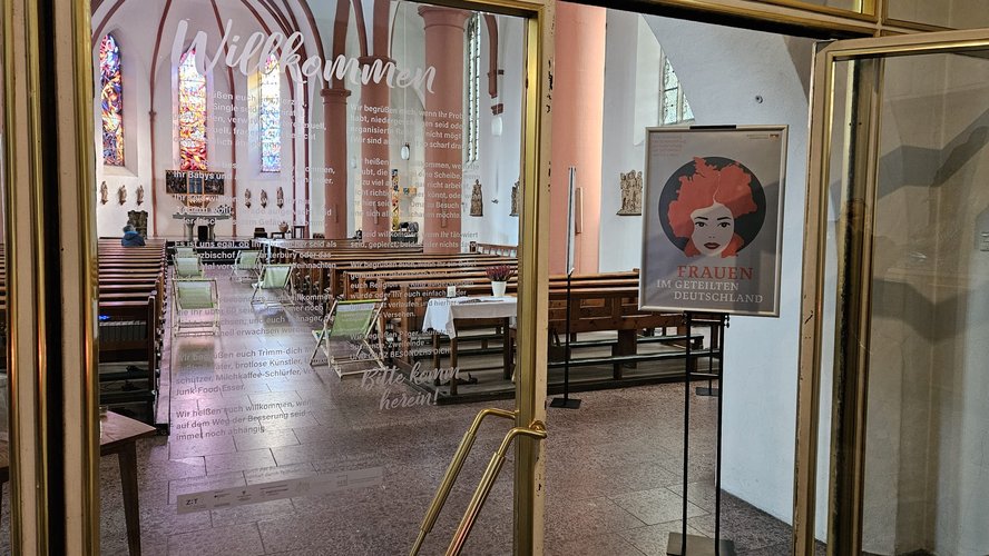 Blick in den Kirchenraum von St. Johannes der Täufer. Im Mittelgang stehen Liegestühle.