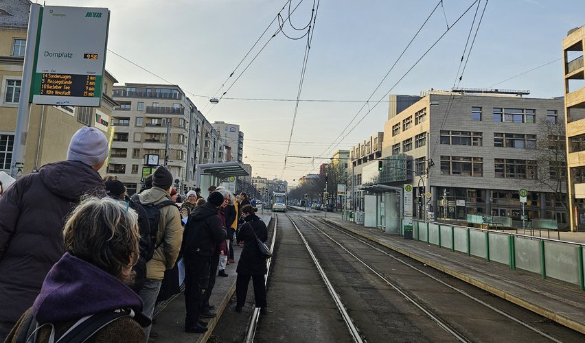 Menschen warten auf eine Straßenbahn